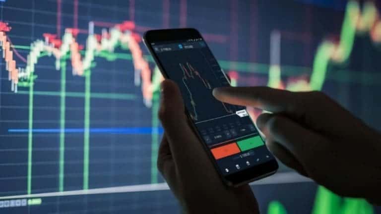 Trader pointing to market platform indicating a profit or loss with consideration to capital gains tax and cfd trading
