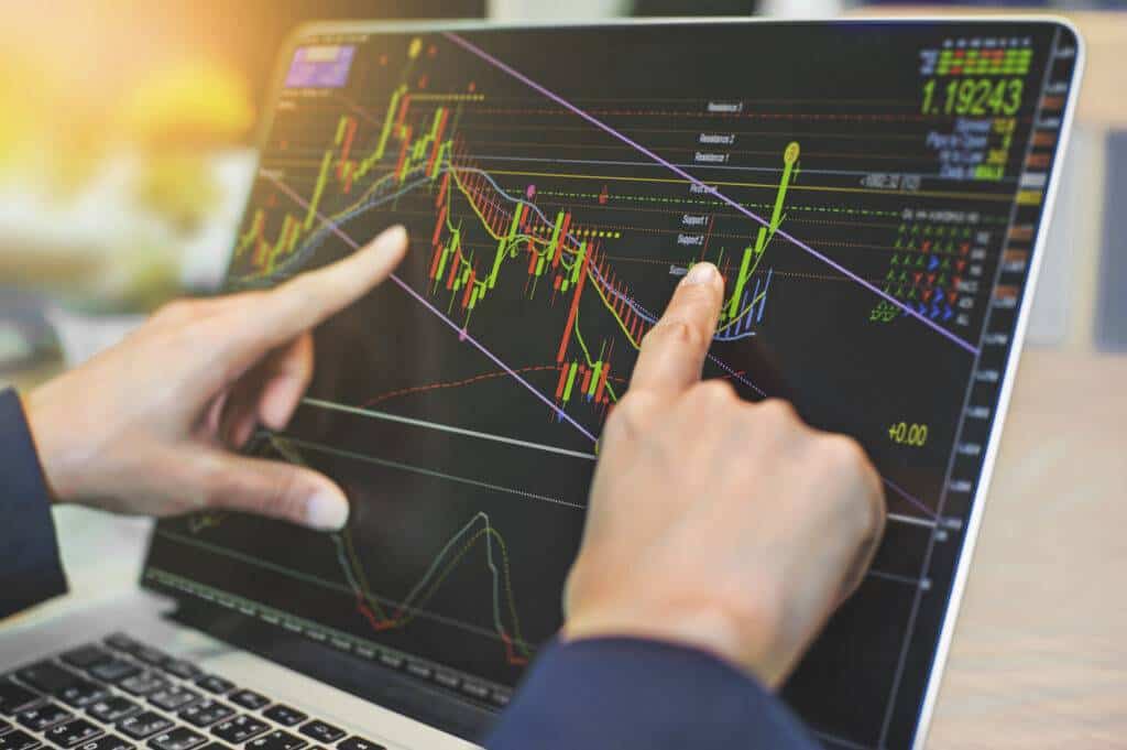 Foreign exchange market trader analyzing charts with indicators and trend lines as a guide.