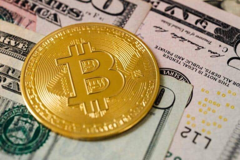 Bitcoin crypto or cryptocurrency is shown on top of fiat currency, specifically US dollars.